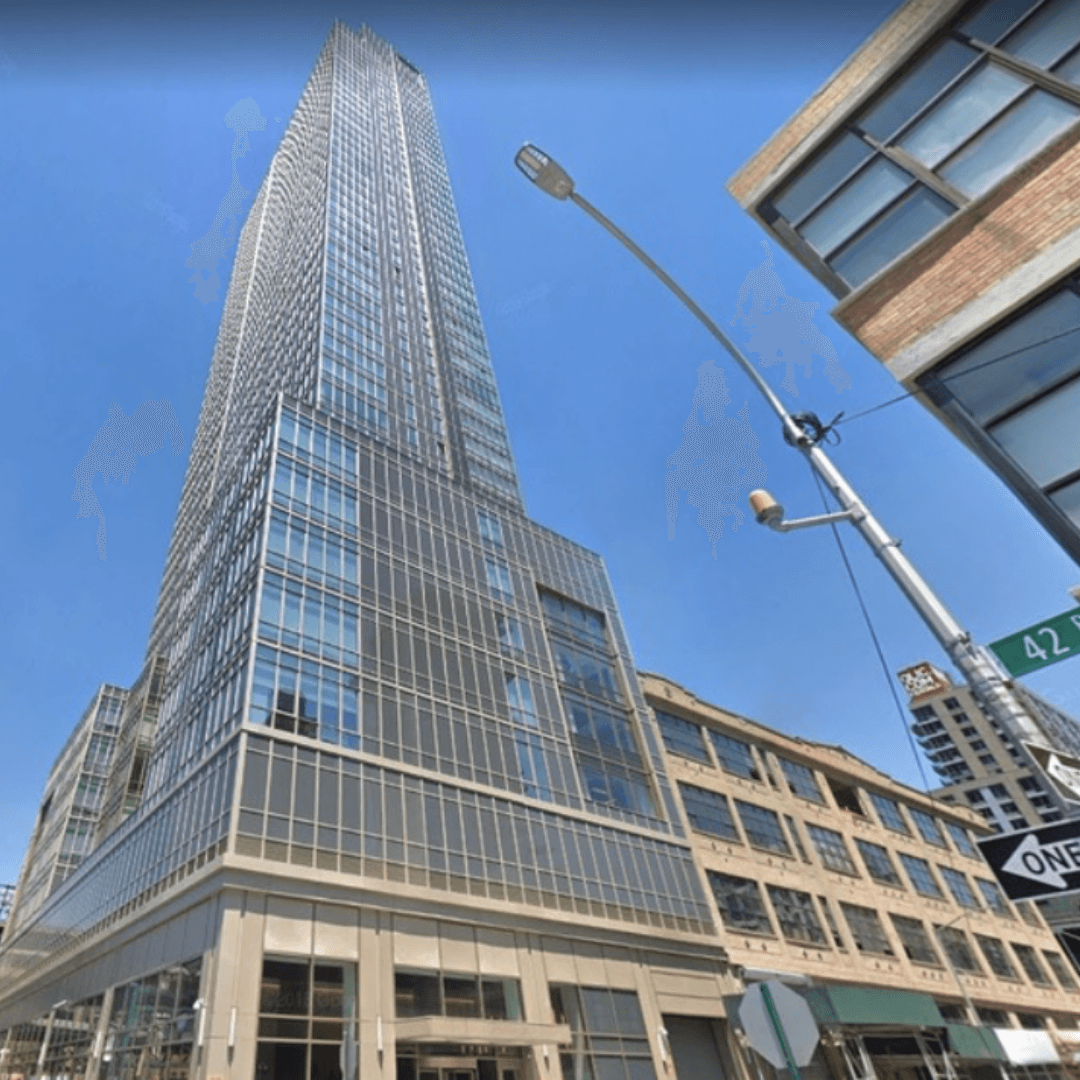 Street level view looking upwards as the QPS Tower goes towards a clear blue sky.